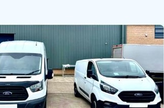 Two Davis Transport Services vans parked outside a storage facility